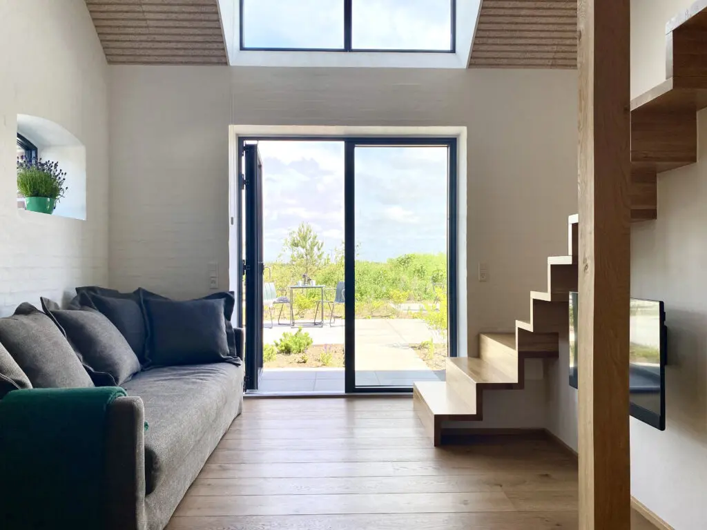 Moellegaarden har lækre ferielejligheder i danmark. Ligger lige ved ringkoebing fjord. Køkkenalrum i lækre materialer, hvor der er mulighed for at spise og smide sig i sofaen. Fra rummet er der en dejlig udsigt til terrassen og naturen.